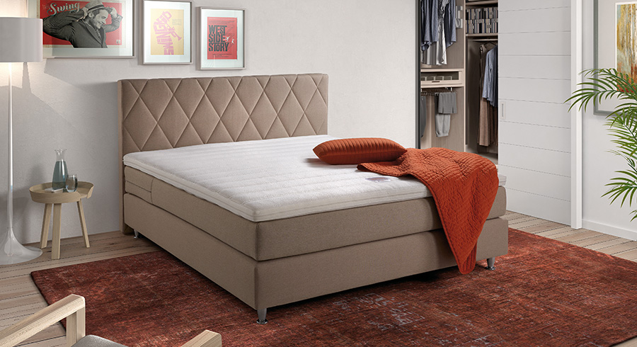 BOXSPRING VELDA VERSUS 3C FIXE tissu bruin 180x200 avec tête de lit dans une chambre